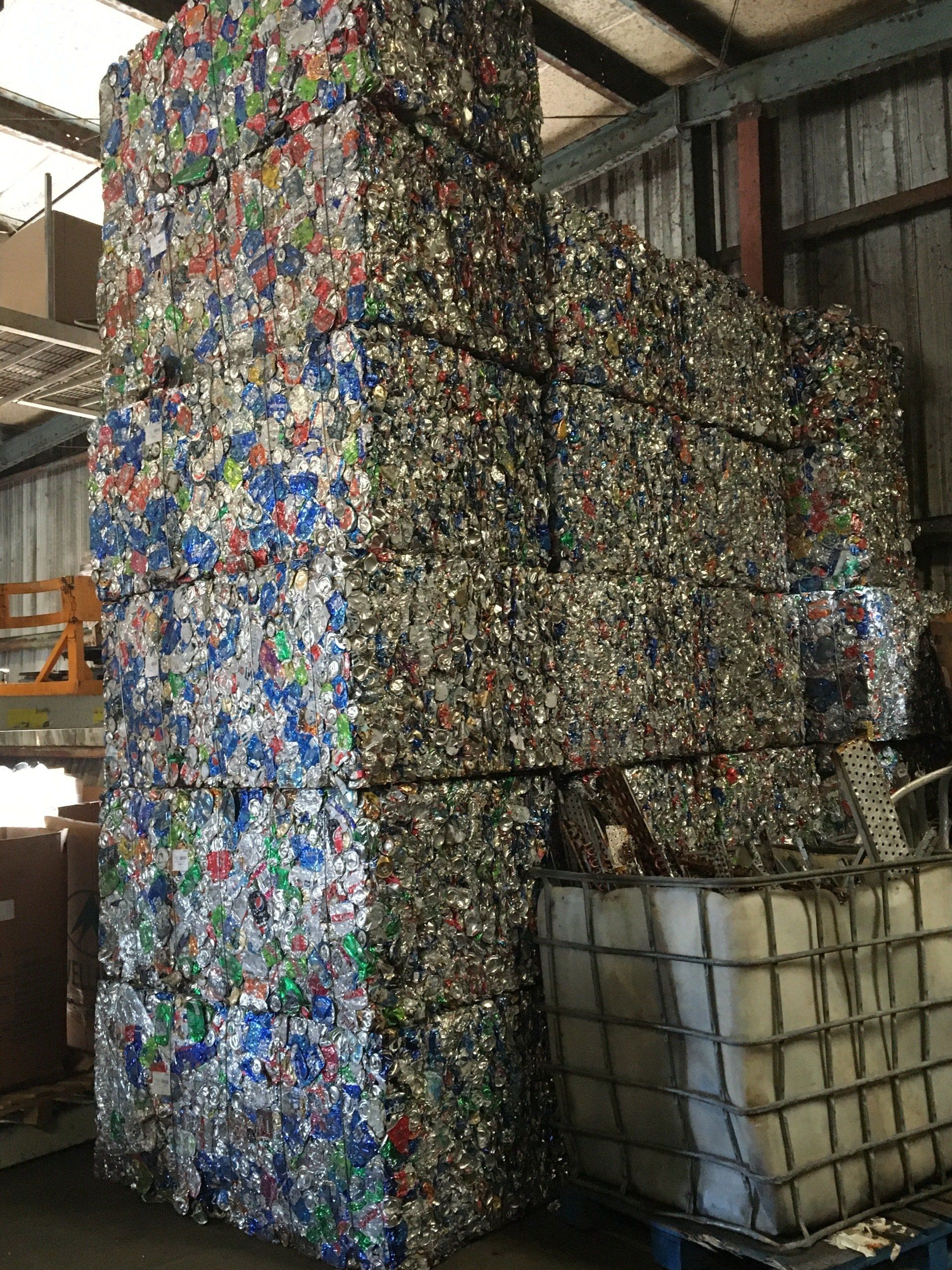 A large pile of plastic bottles stacked on top of each other in a warehouse.