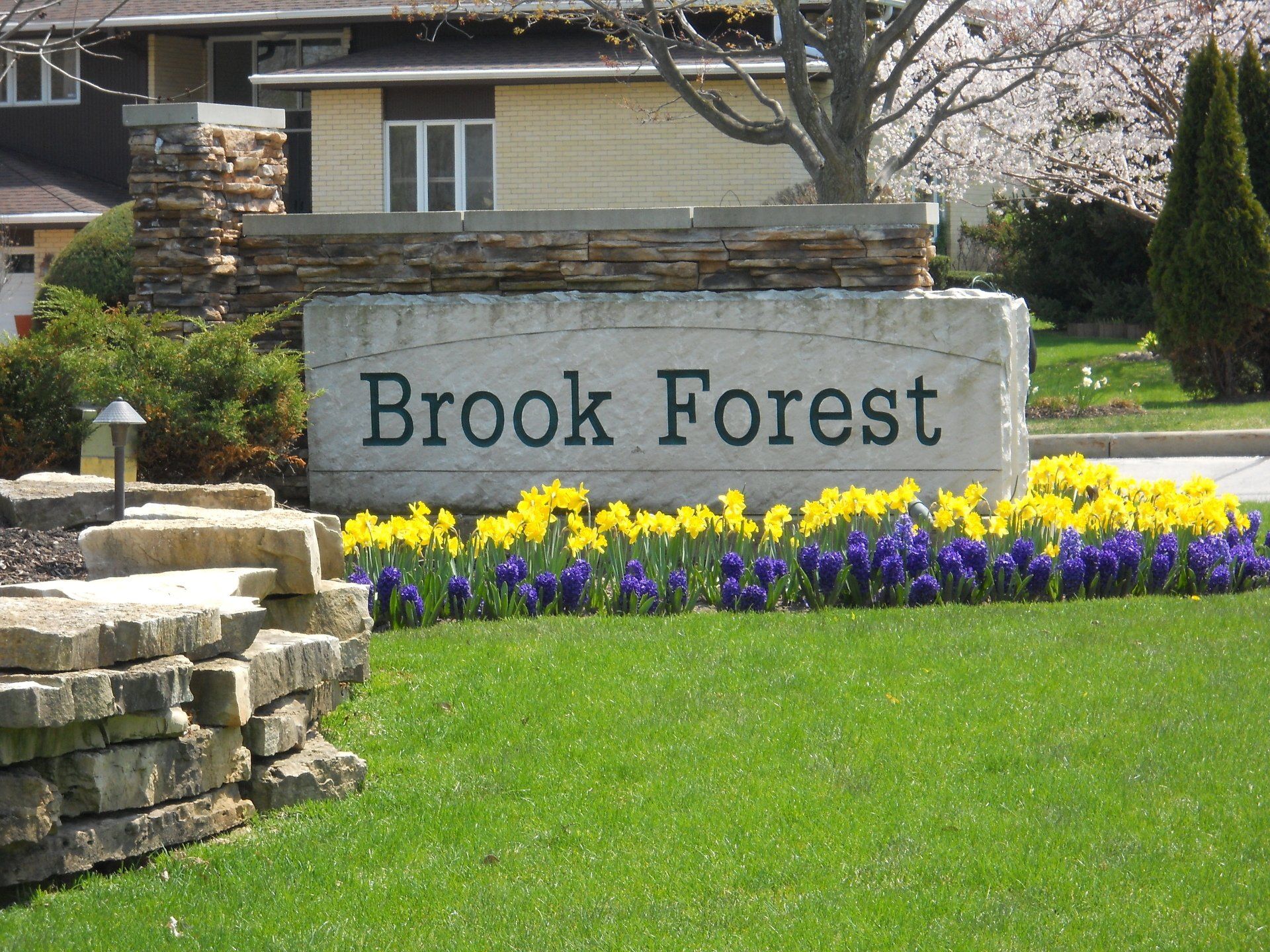 A sign that says brook forest in front of a house