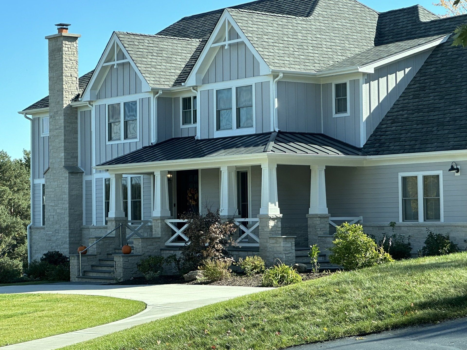 A large house with a large porch and a chimney