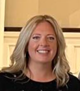 A woman with blonde hair is smiling and wearing a black shirt.