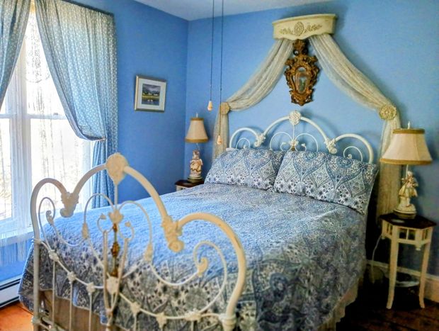 a bedroom with blue walls and a white bed