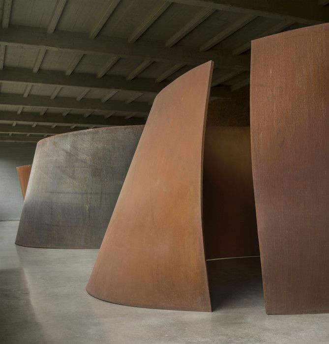 a row of curved metal sculptures in a room
