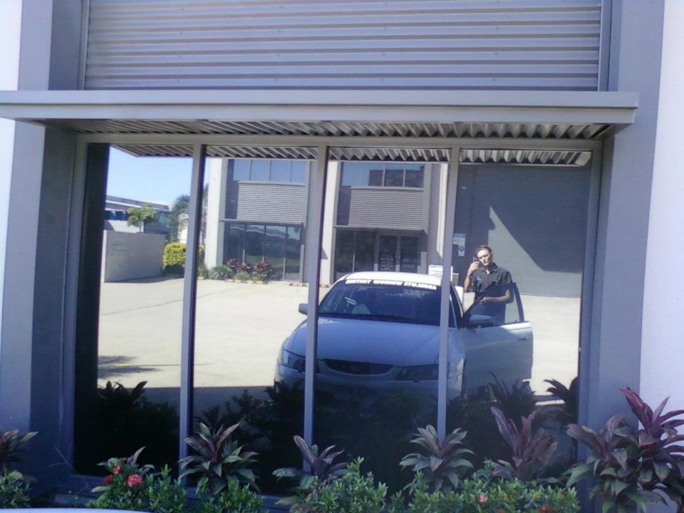 A White Car Is Parked in Front of A Building β Epic Window Tinting in Glenella, QLD