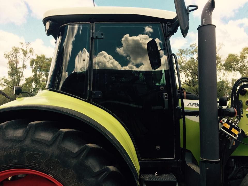 A Green and White Tractor with A Red Wheel — Epic Window Tinting in Sarina, QLD