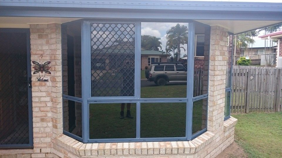 A Brick House with A Large Window and A Car Parked in Front of It — Epic Window Tinting in Sarina, QLD