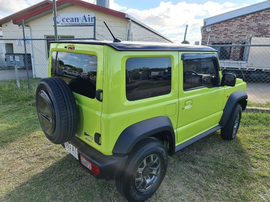 A Green Suzuki Jimny Is Parked in Front of A Building β Epic Window Tinting in Glenella, QLD