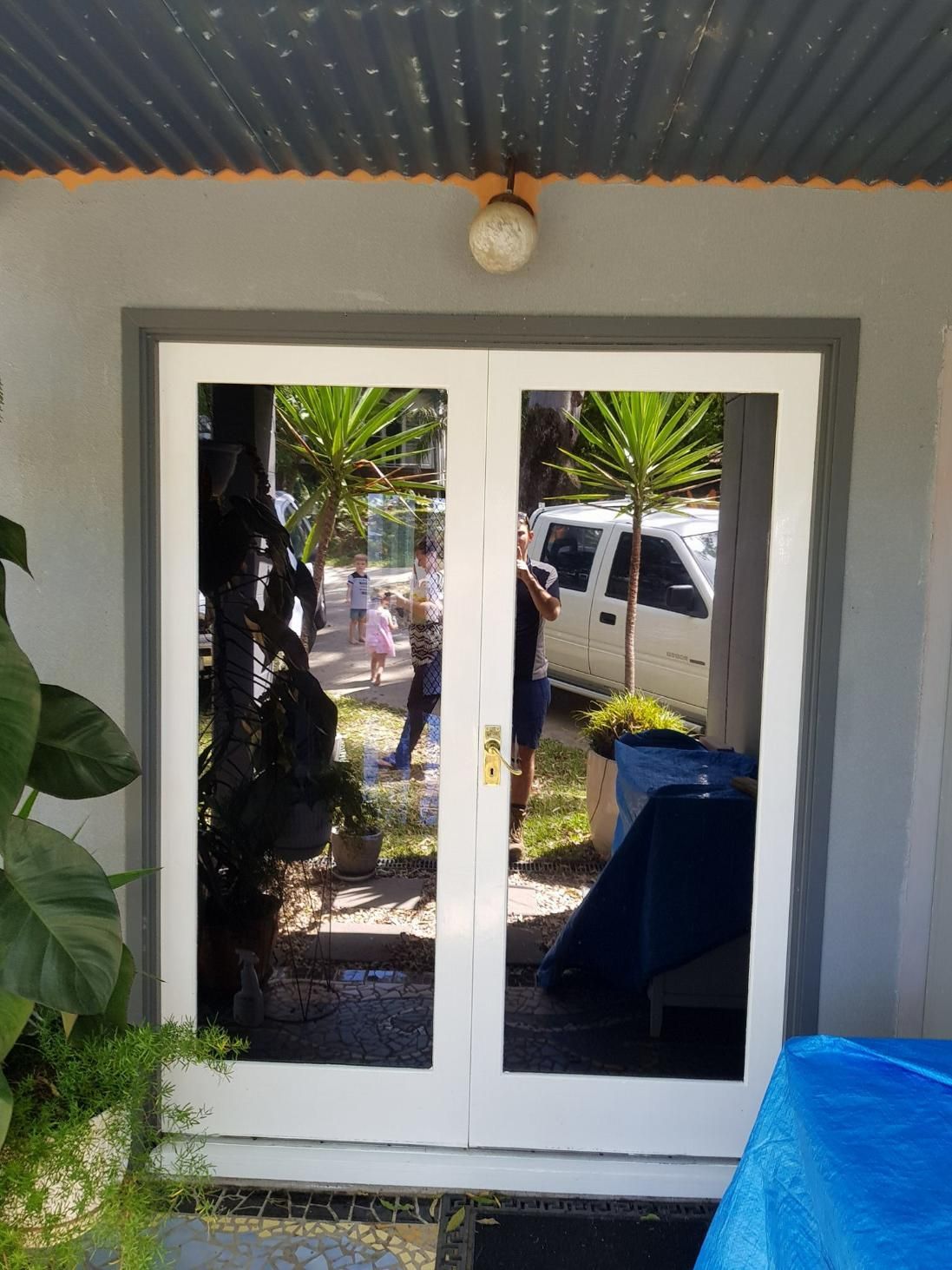 A White Door with A Blue Tarp in Front of It — Epic Window Tinting in Sarina, QLD