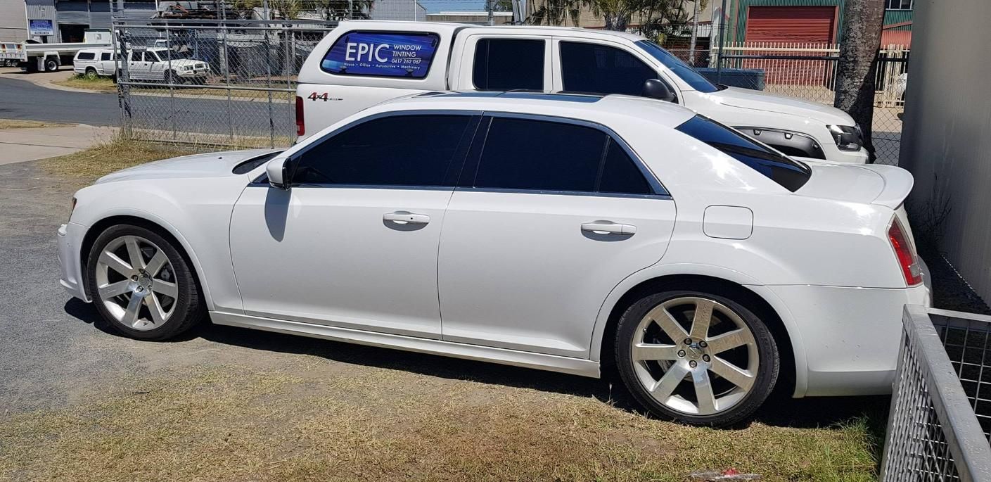 A White Car Is Parked Next to A White Truck — Epic Window Tinting in Mackay, QLD