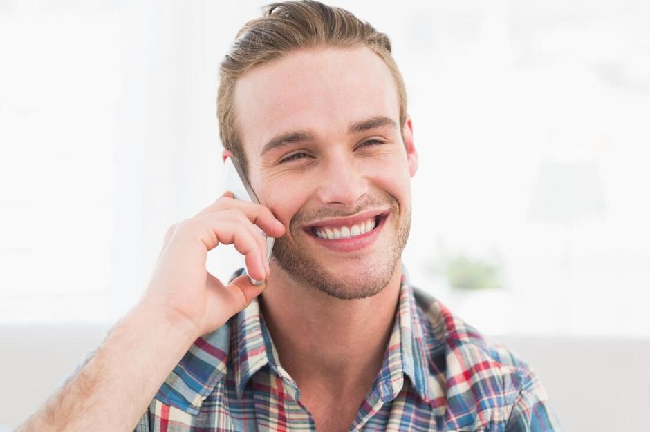 Smiling man holding a mobile phone to his ear