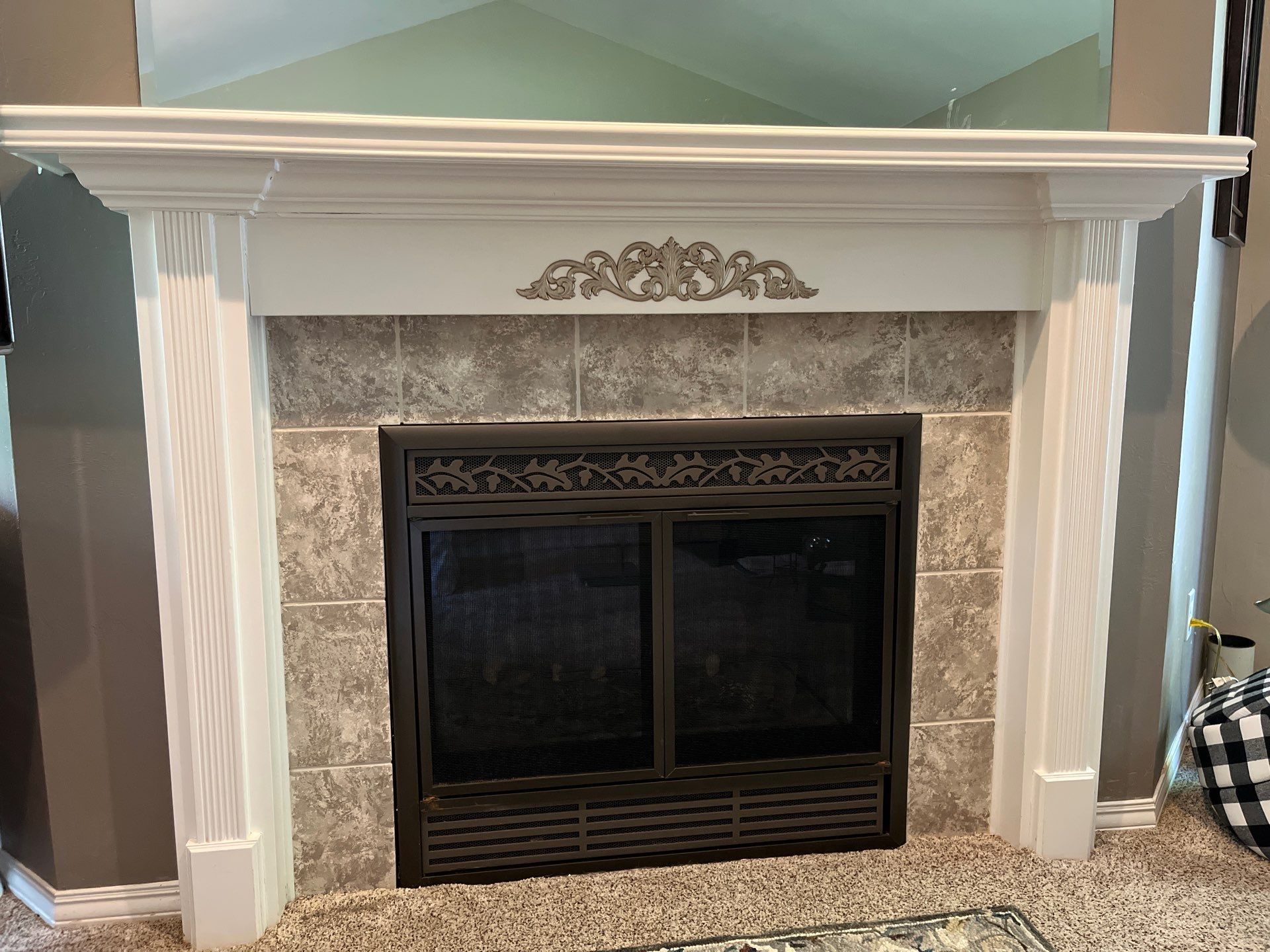A fireplace with a mantle and a mirror in a living room.