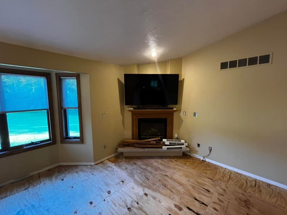 A living room with a fireplace and a flat screen tv on the wall.