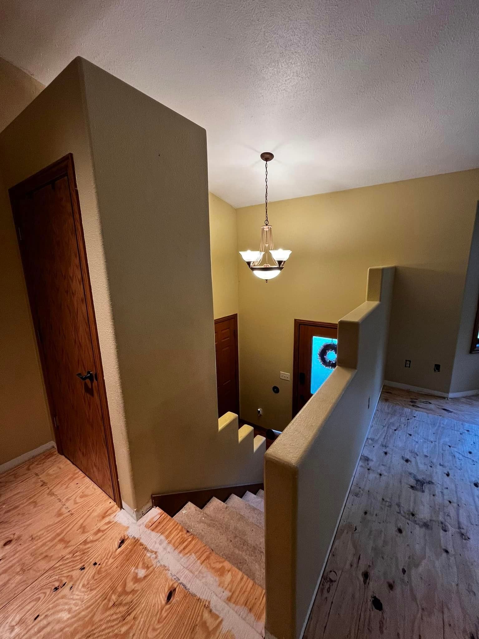 A staircase in a house with a chandelier hanging from the ceiling.