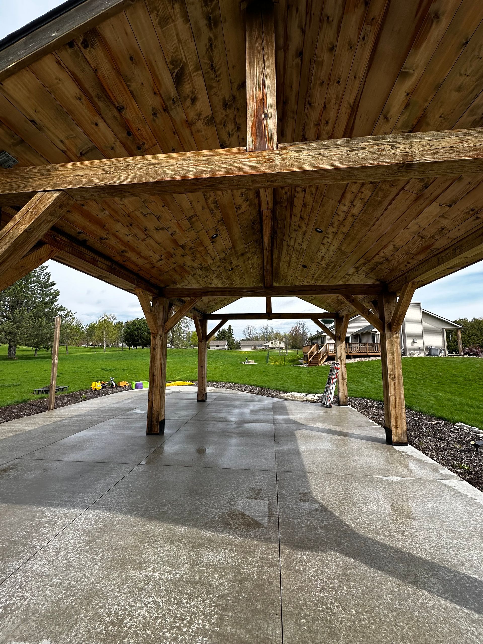 The inside of a wooden pavilion with a concrete floor.