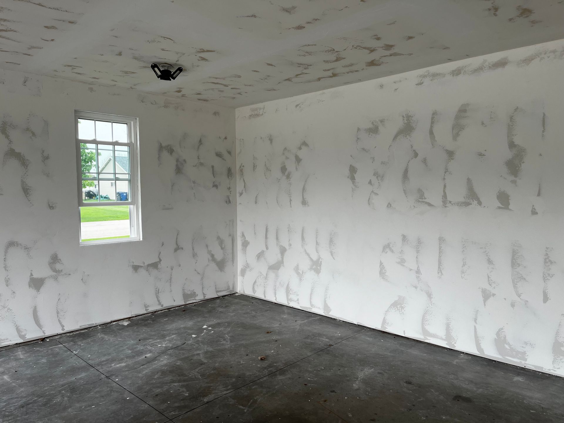 An empty room with graffiti on the walls and a window.