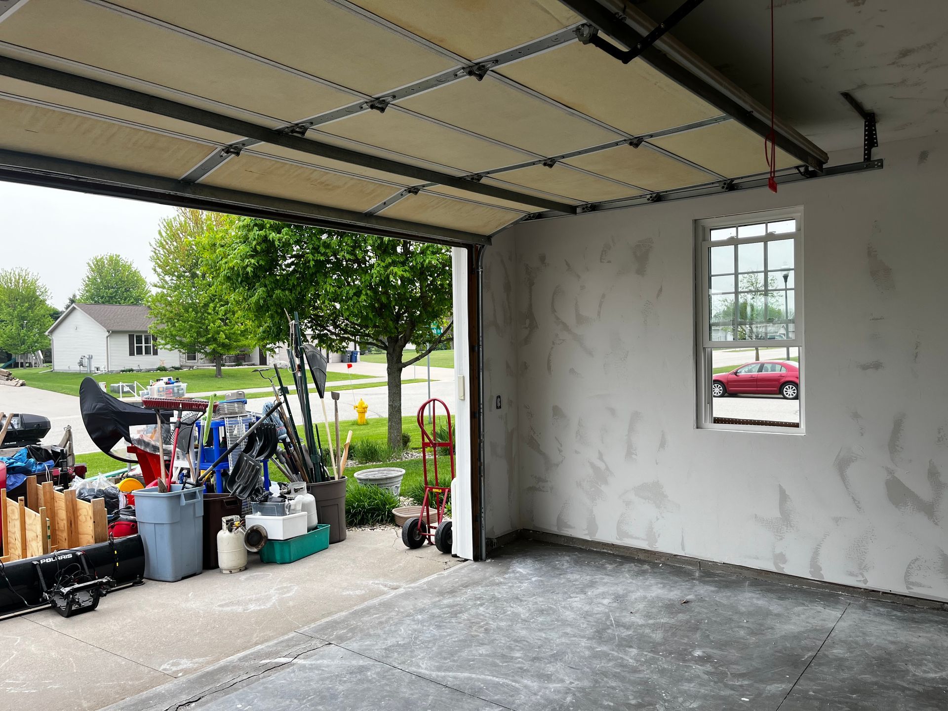 An empty garage with the door open and a window