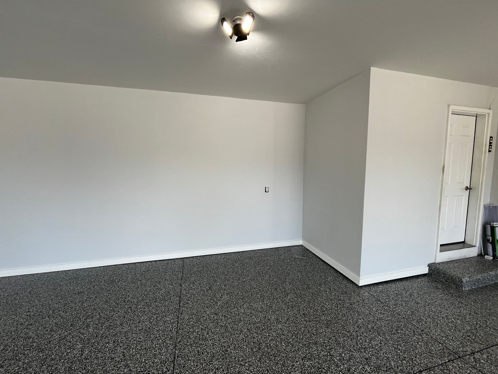 A large empty room with a gray carpet and white walls.