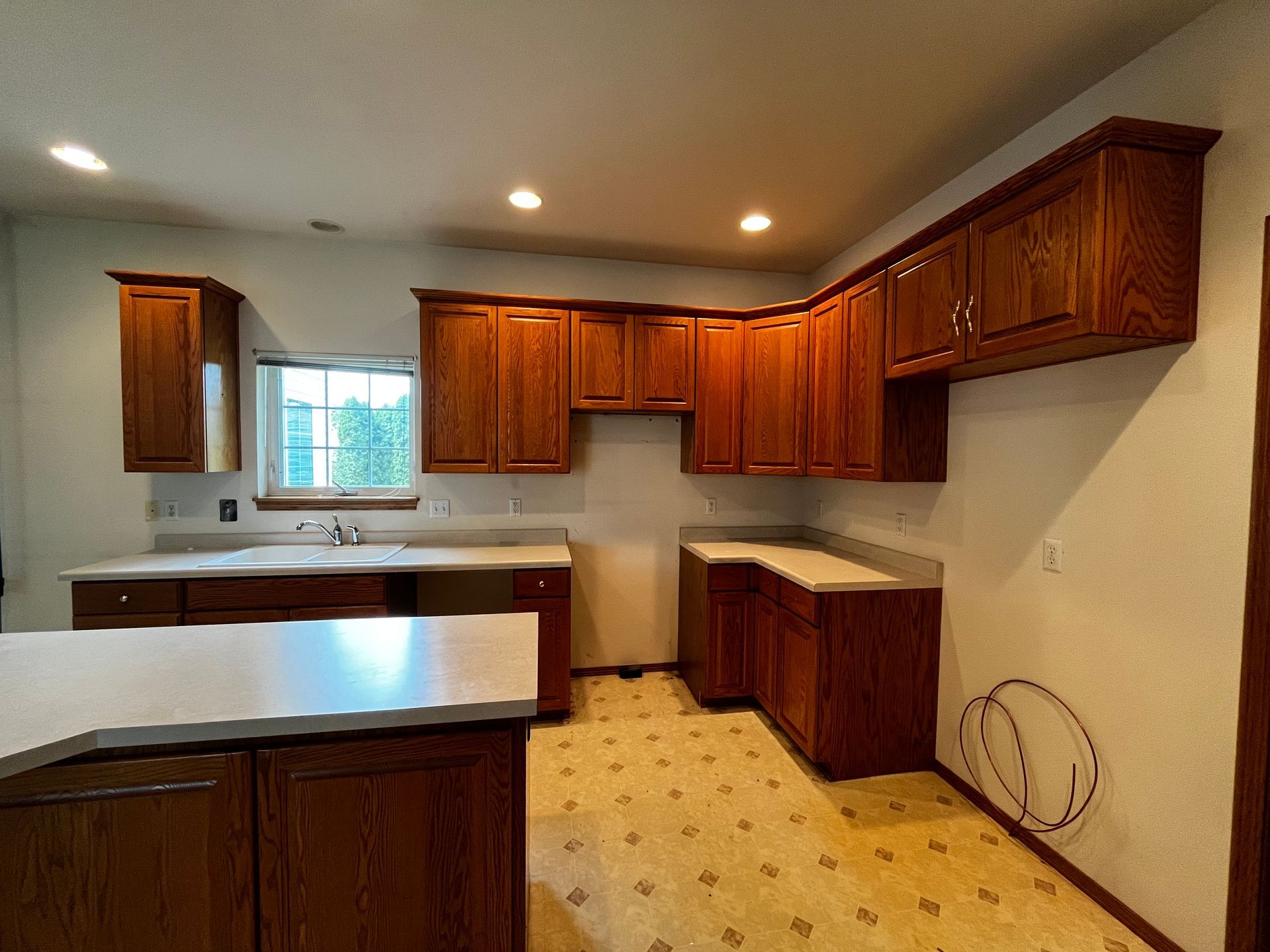A kitchen with wooden cabinets and a white counter top