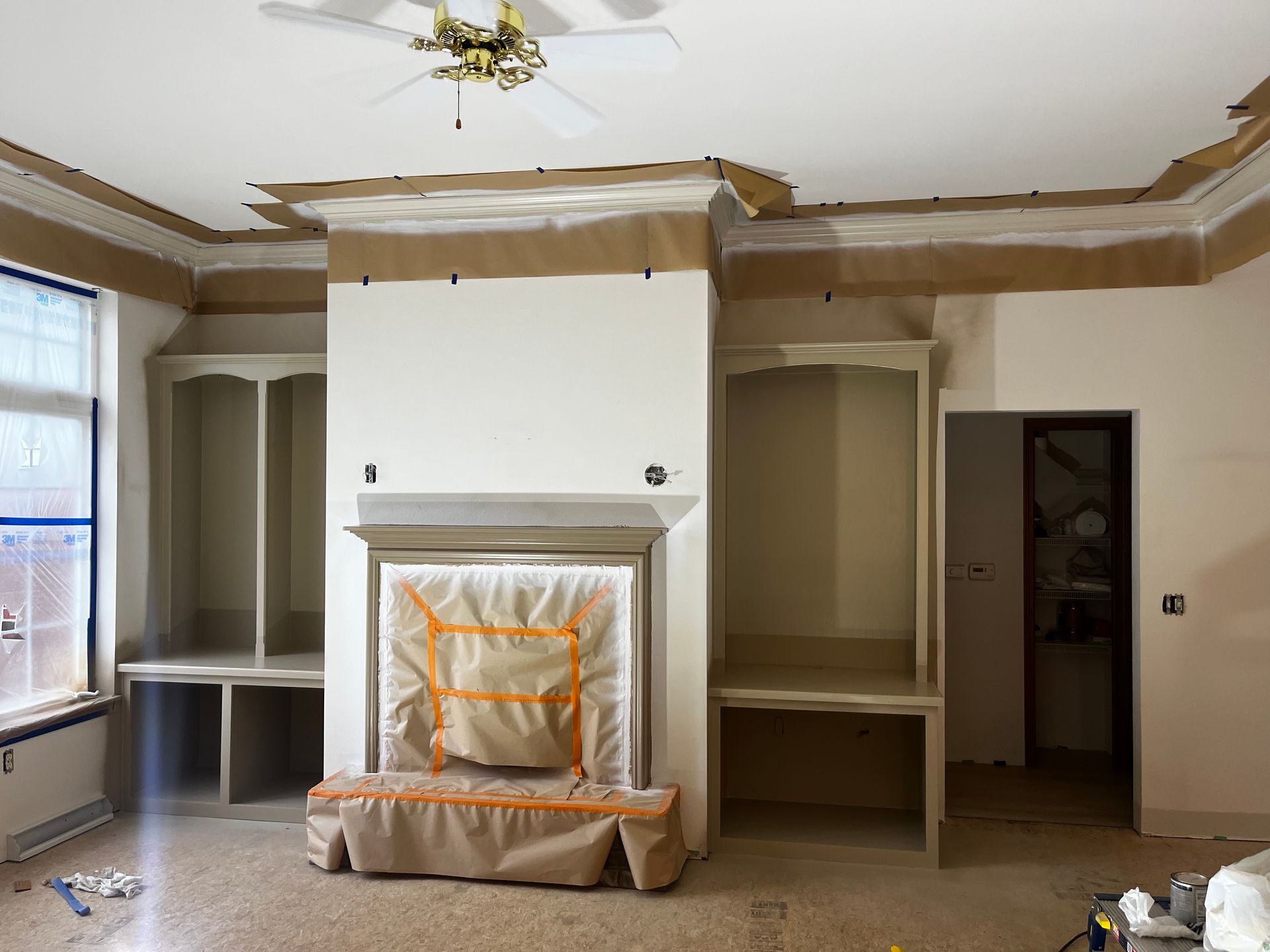 A living room with a fireplace and a ceiling fan