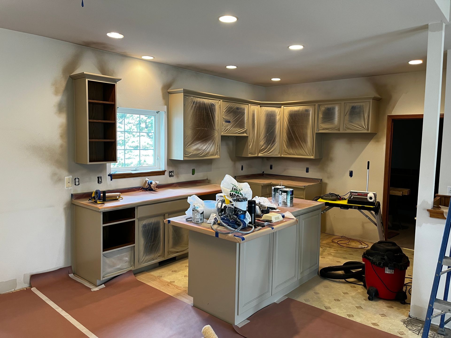 A kitchen under construction with a vacuum cleaner on the floor.