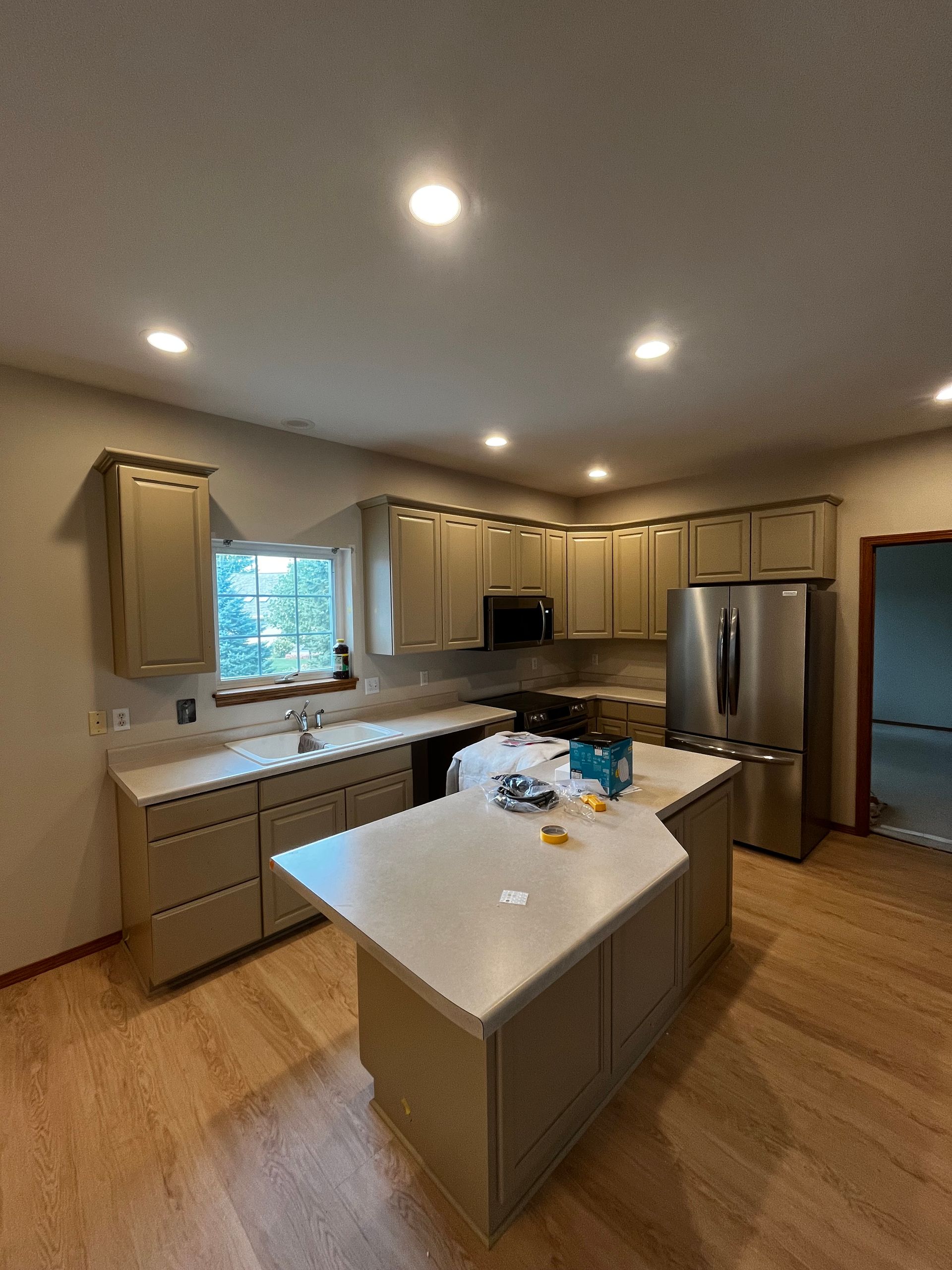 A kitchen with stainless steel appliances and a large island.