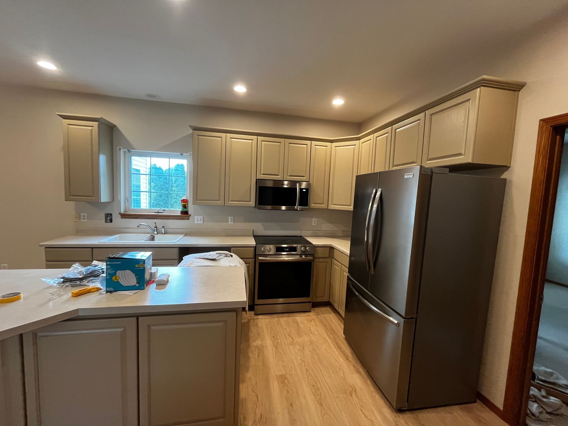 A kitchen with stainless steel appliances and white cabinets is being remodeled.