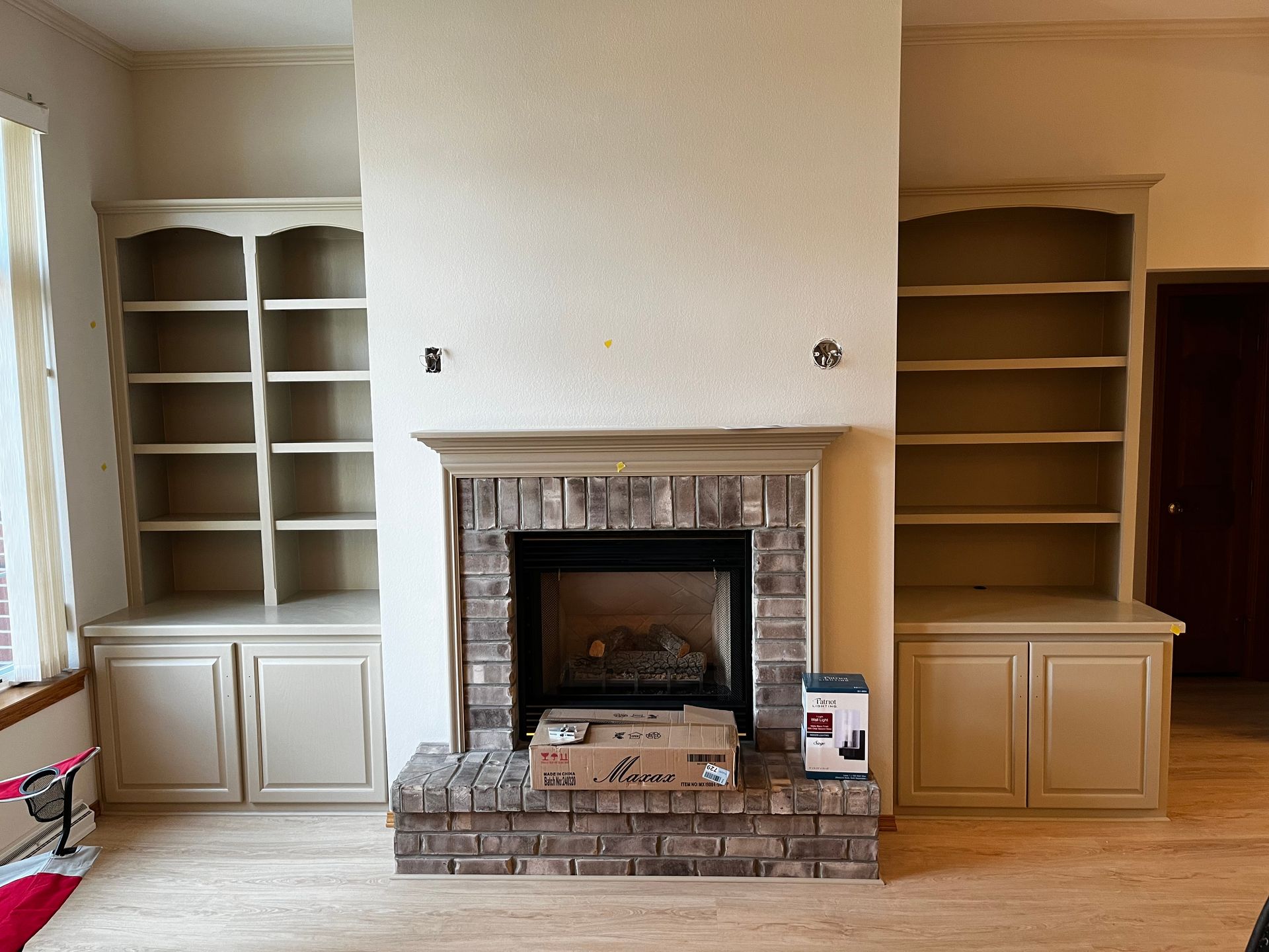 A living room with a fireplace and built in shelves