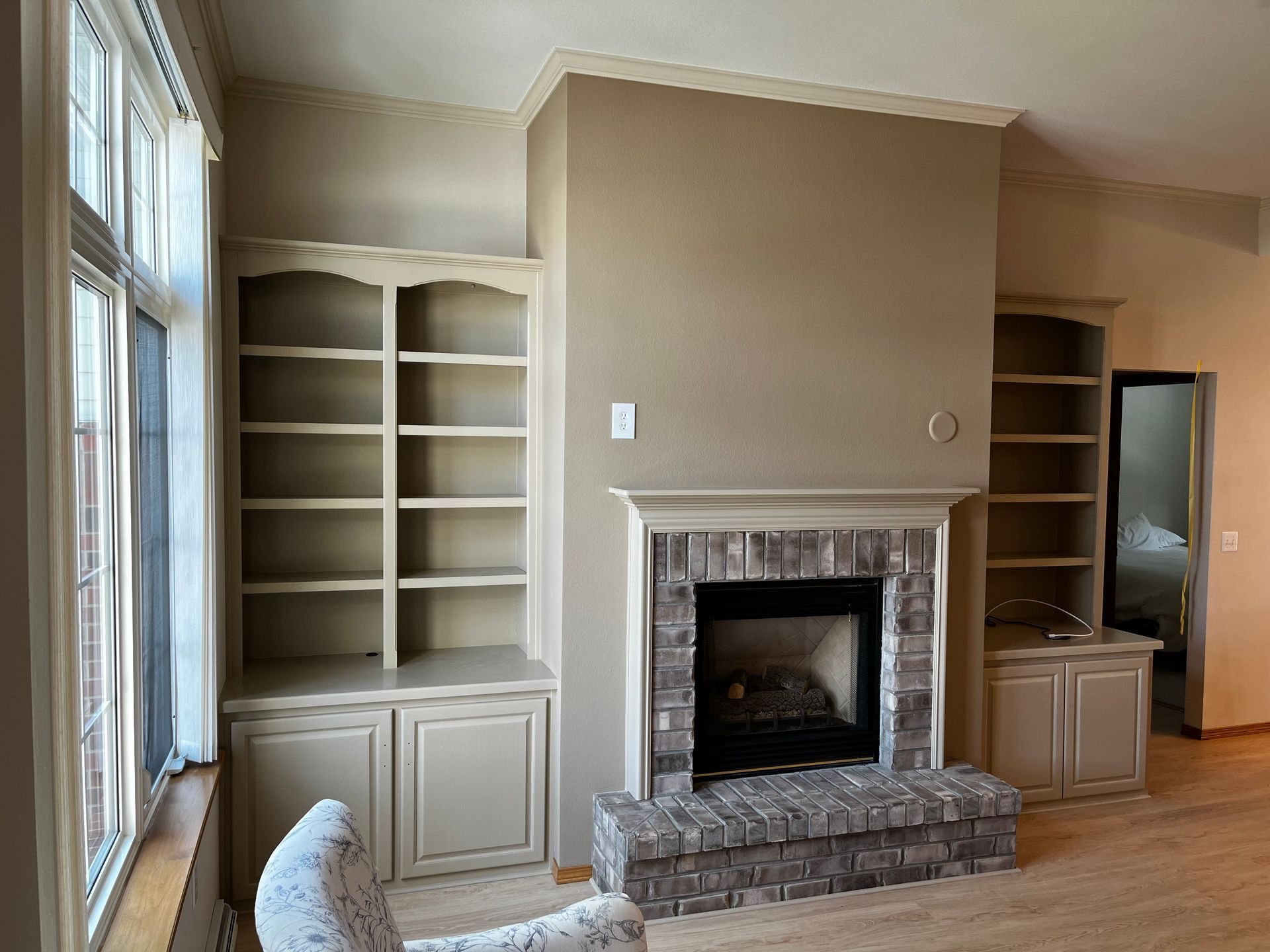 A living room with a fireplace and built in shelves