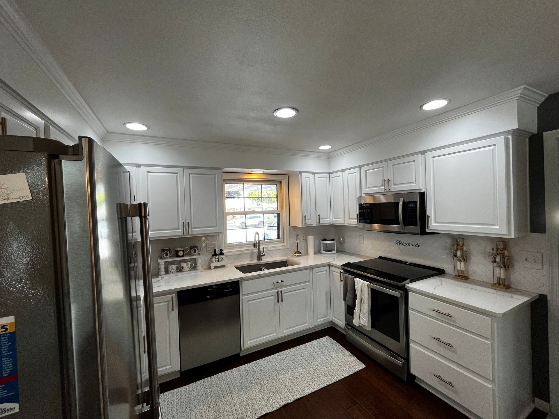 A kitchen with white cabinets and stainless steel appliances.