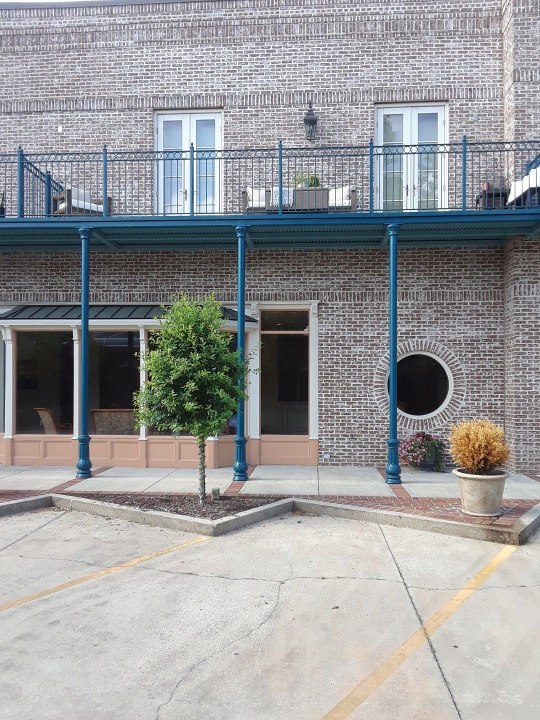 A brick building with a balcony and a round window