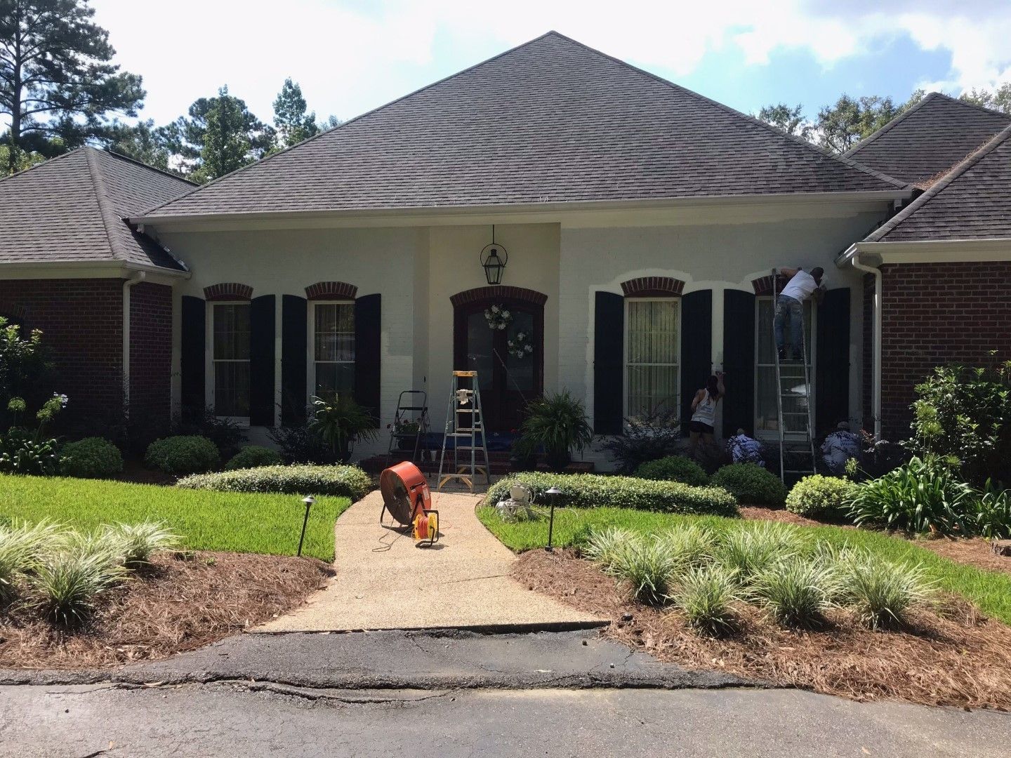 A man is working on a walkway in front of a house