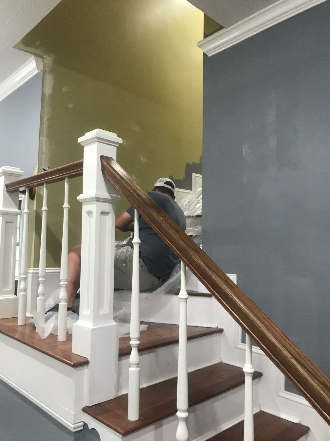 A man is sitting on the railing of a staircase.