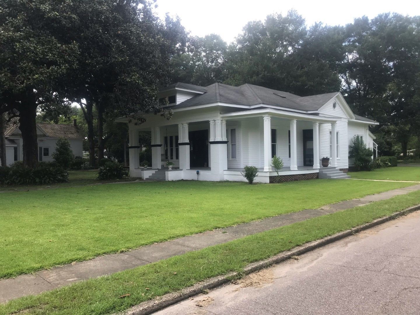 A white house with a large lawn in front of it