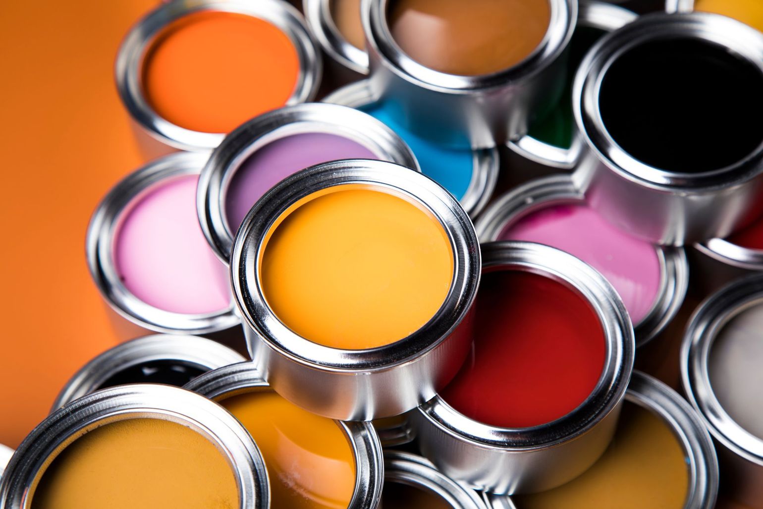 A bunch of paint cans are stacked on top of each other