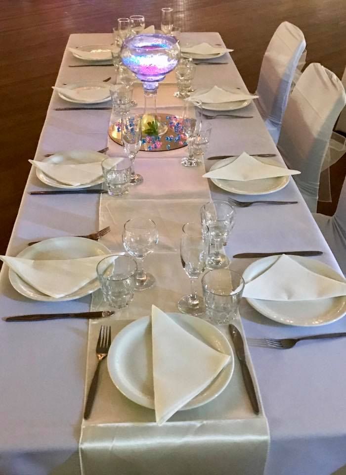 A Long Table with Plates, Glasses, and Napkins on It — Creative Events Innisfail in Mission Beach, QLD