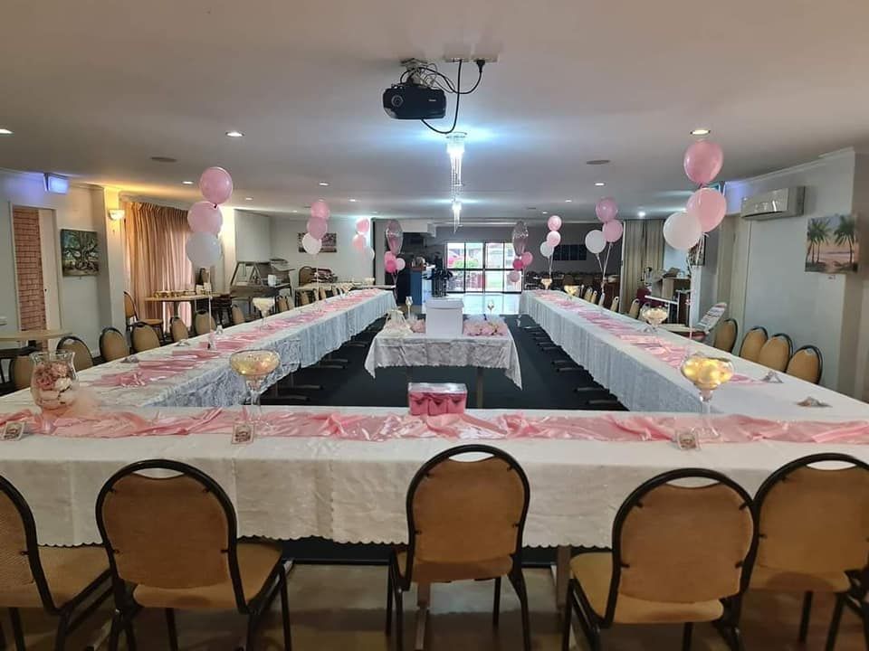 A Large Room with Tables and Chairs and Balloons on The Ceiling — Creative Events Innisfail in Mission Beach, QLD