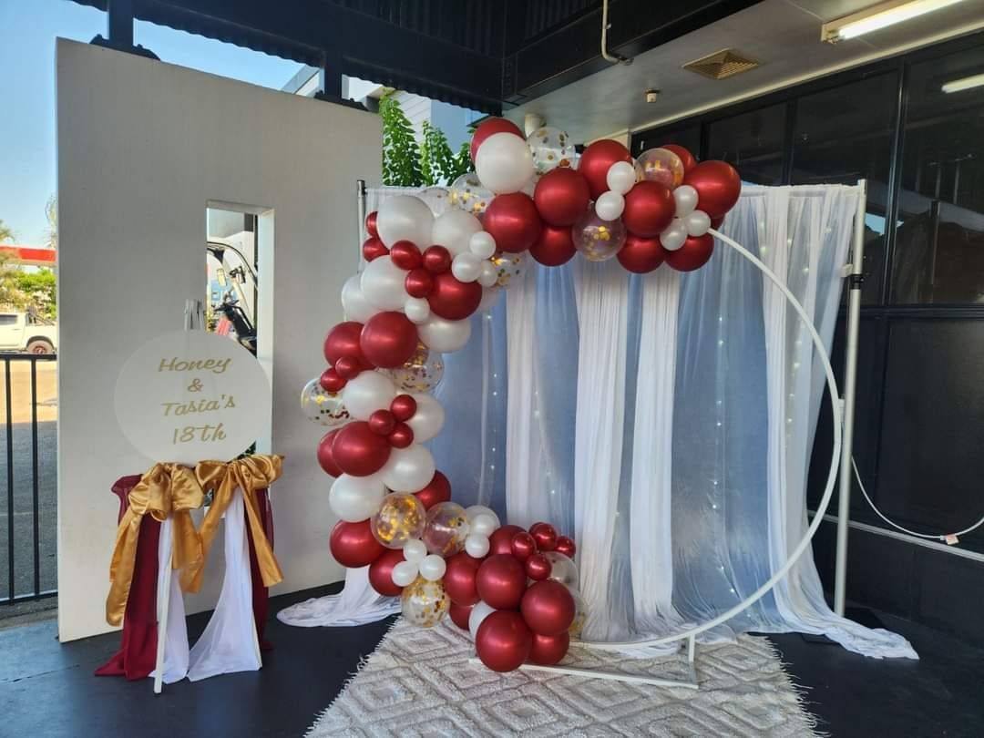A Red and White Balloon Arch Is Sitting in Front of A White Wall — Creative Events Innisfail in Mission Beach, QLD