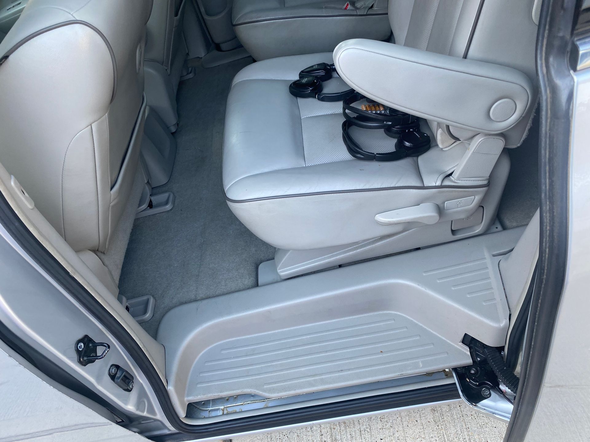 The back seat of a car with the door open and the seats folded down.