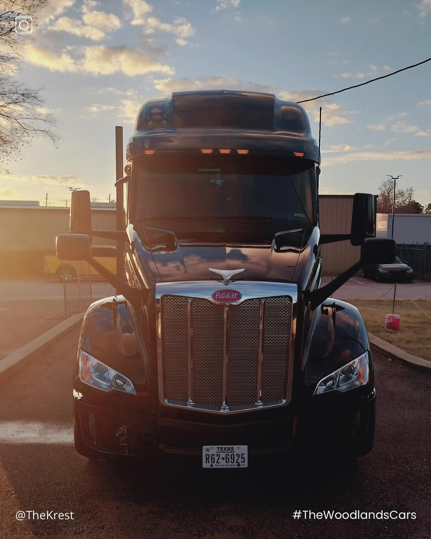 A black semi truck is parked on the side of the road