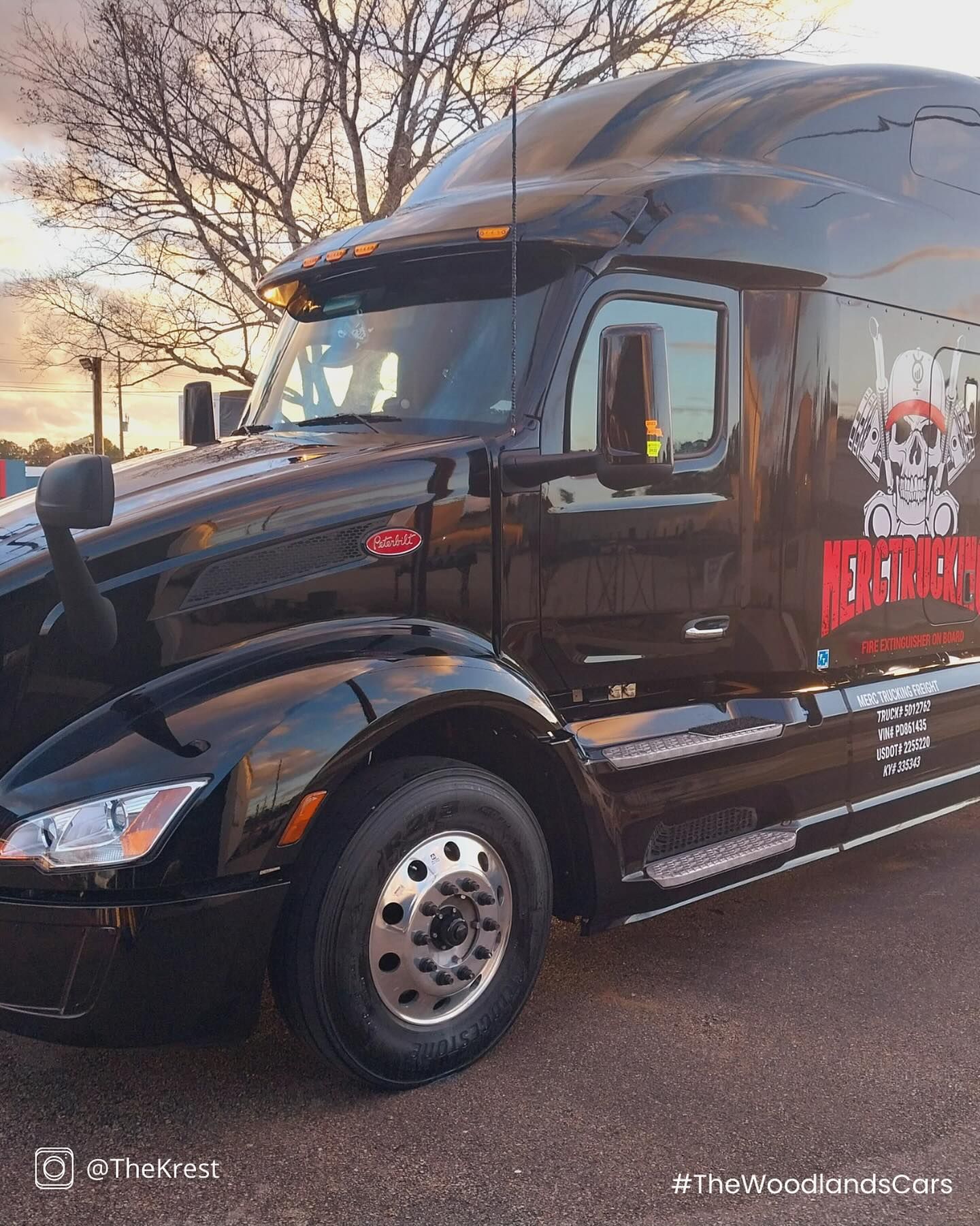 A black semi truck is parked on the side of the road.