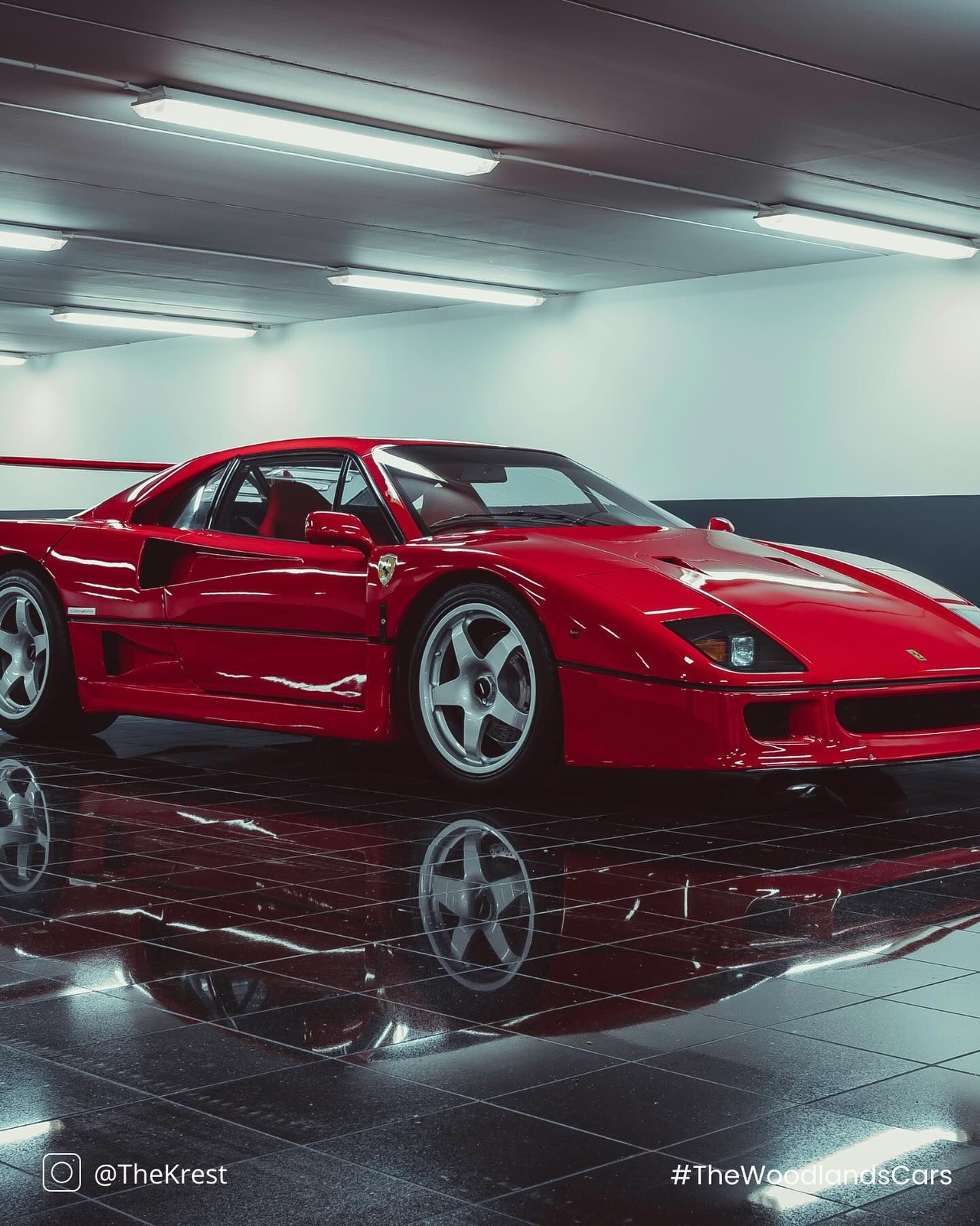 A red sports car is parked in a garage.
