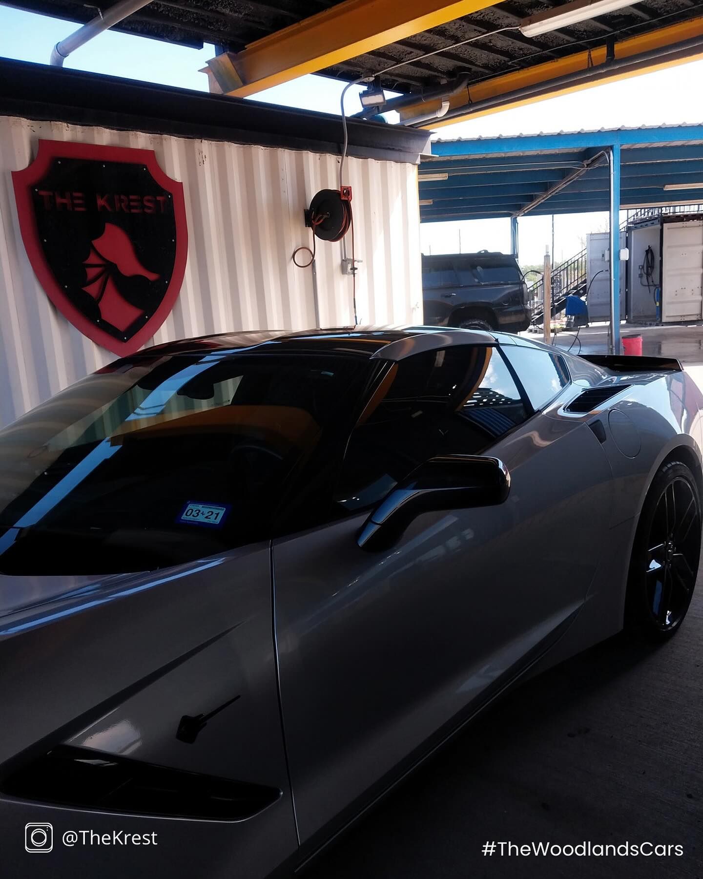 A silver sports car is parked in front of a building.
