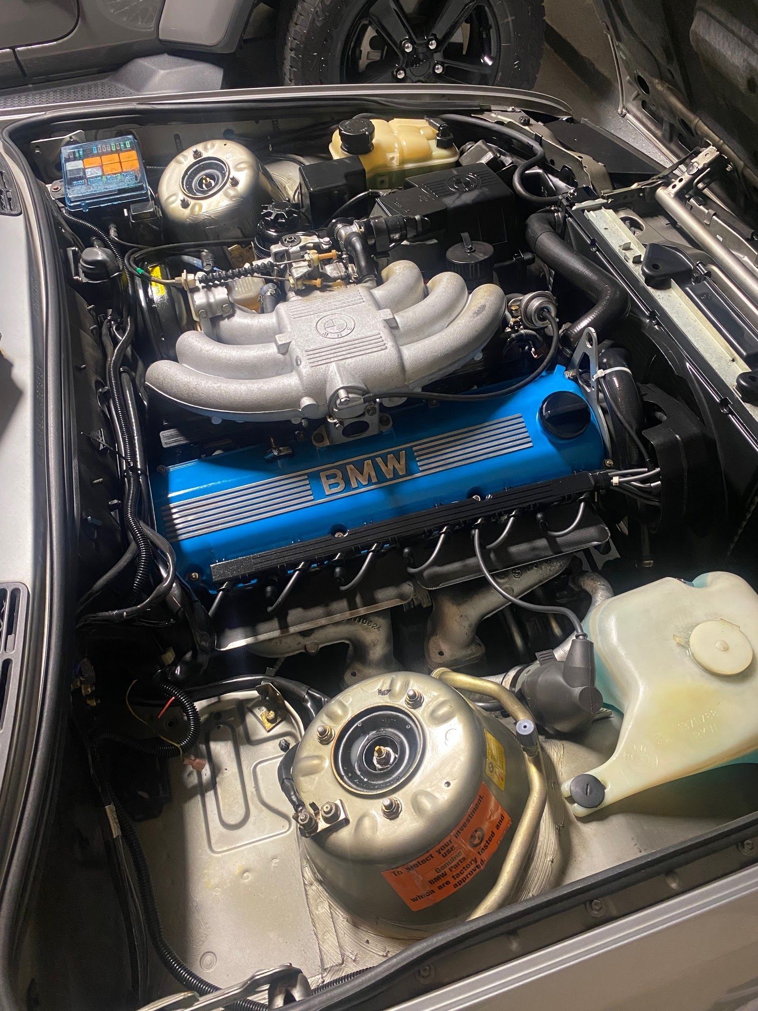 A bmw engine is sitting under the hood of a car.