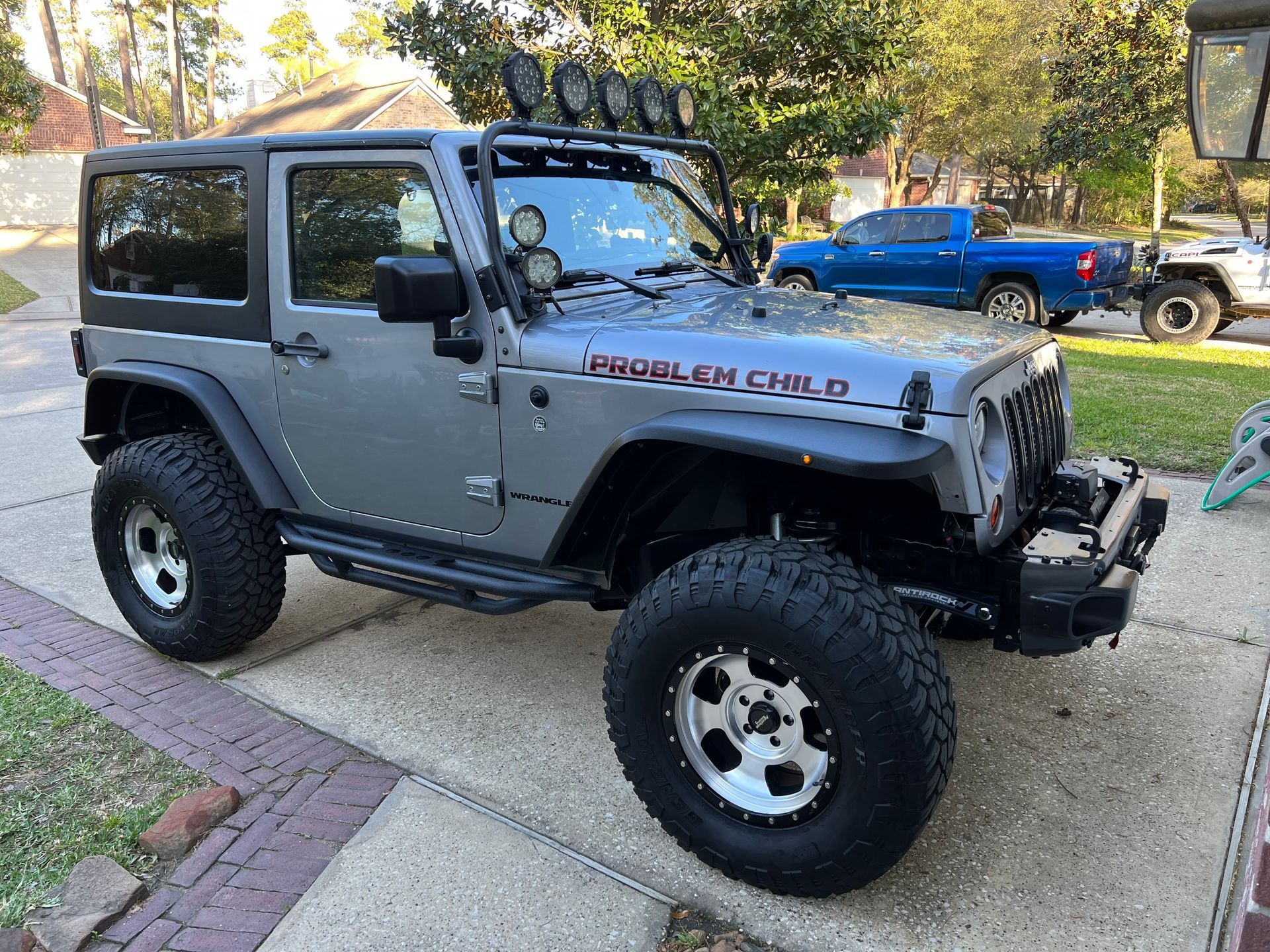 A gray jeep is parked on the side of the road.