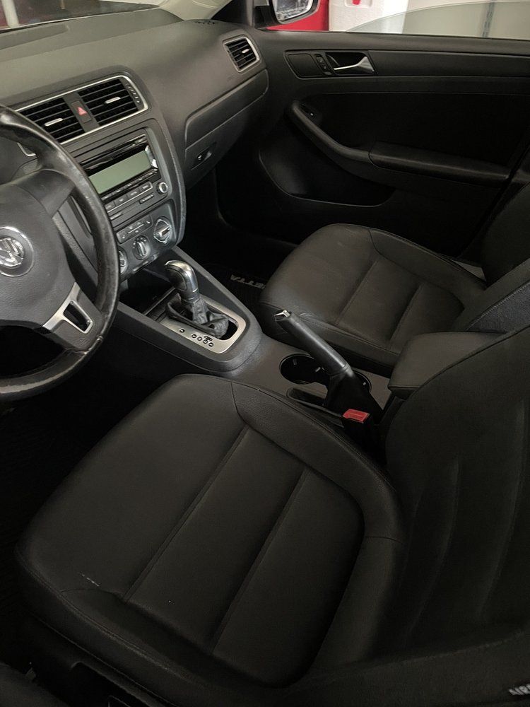 The interior of a volkswagen jetta with leather seats and a steering wheel