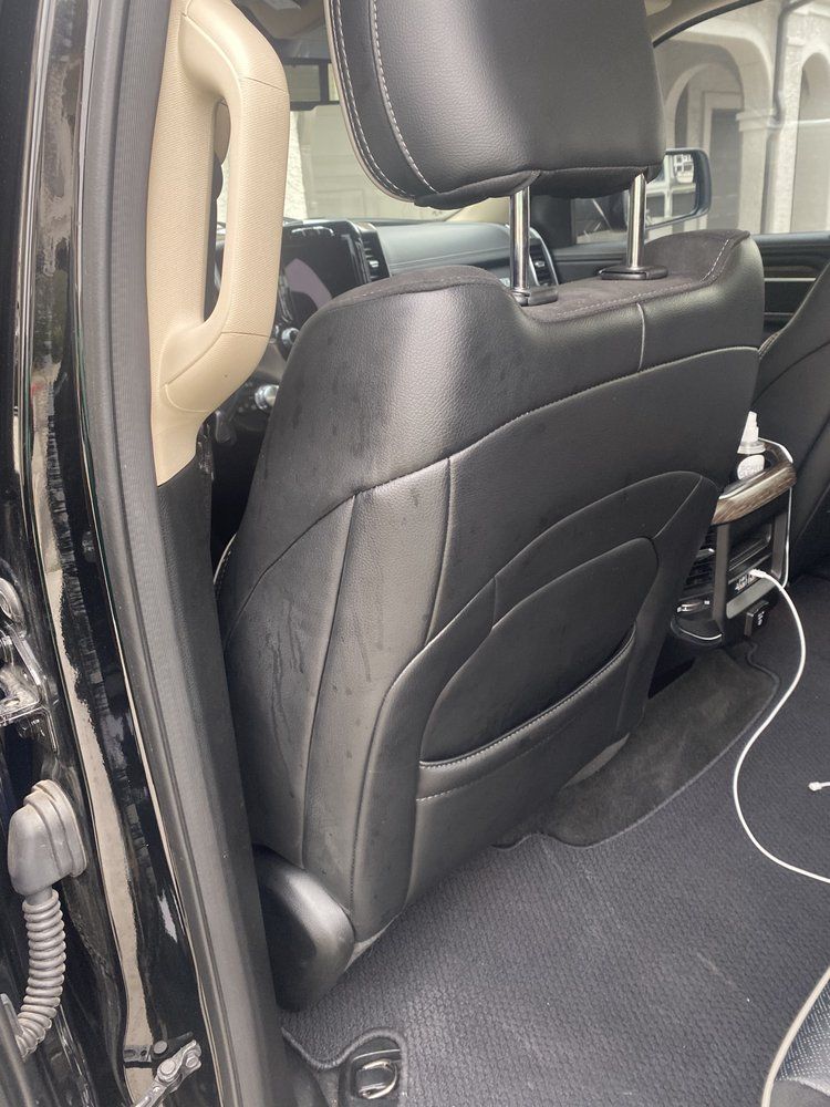 A close up of the back seat of a car with a headrest.