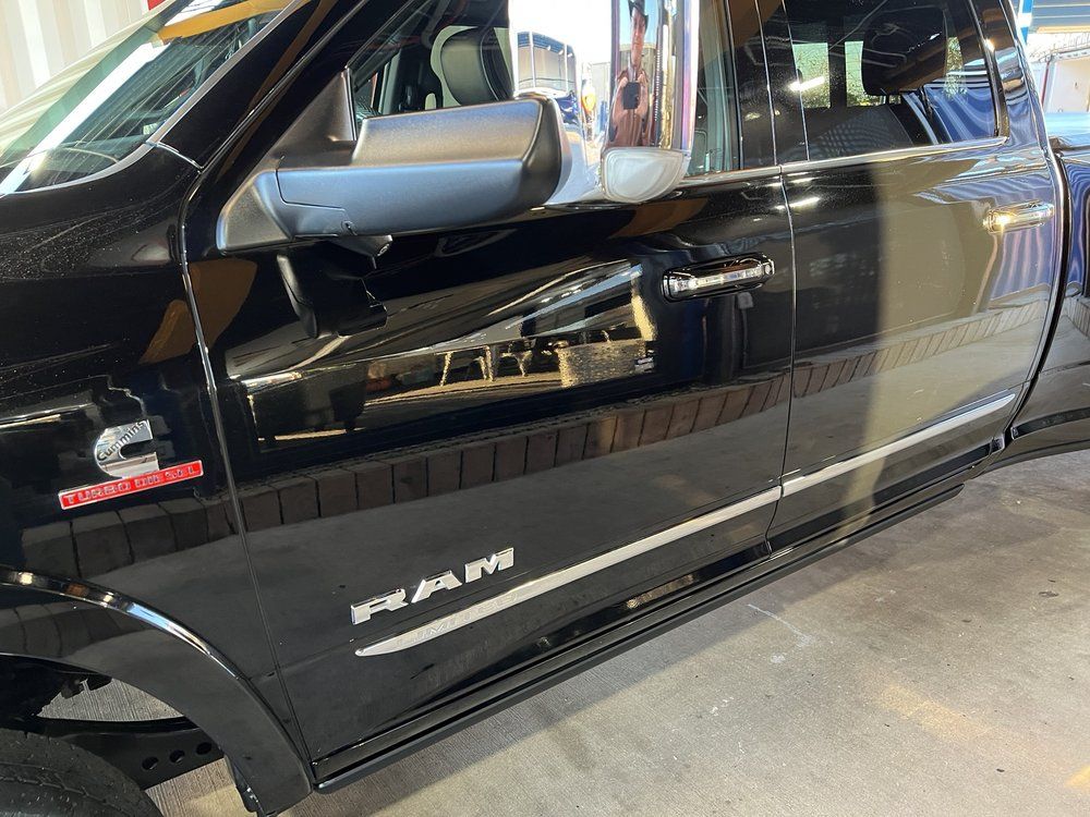 A black dodge ram truck is parked in a garage.