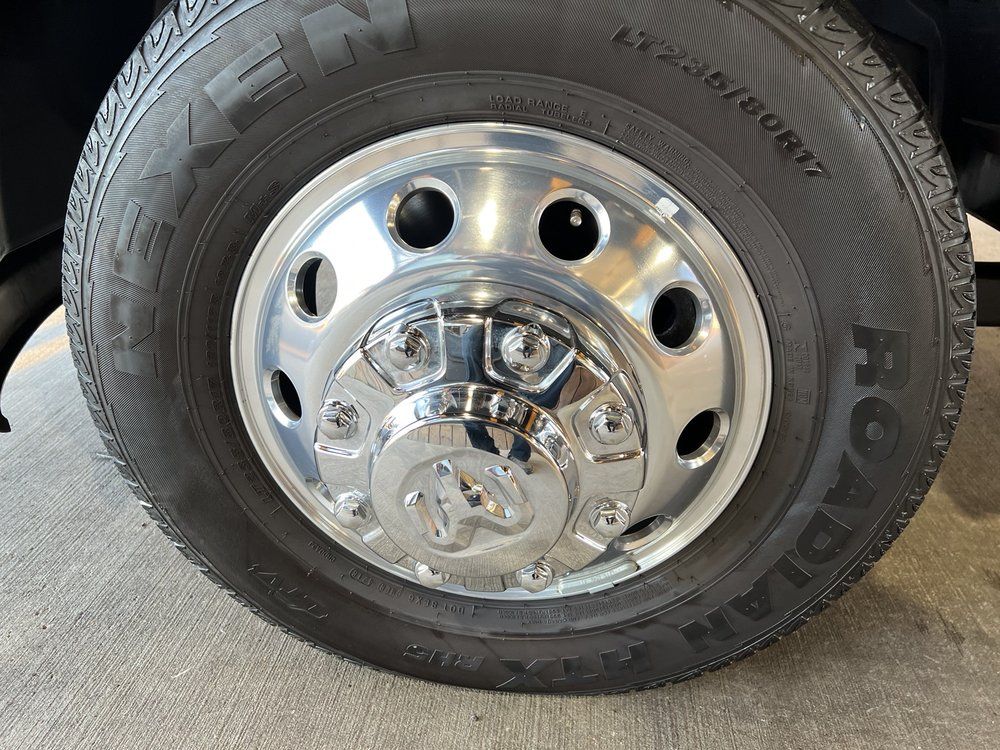 A close up of a tire on a truck with a chrome rim.