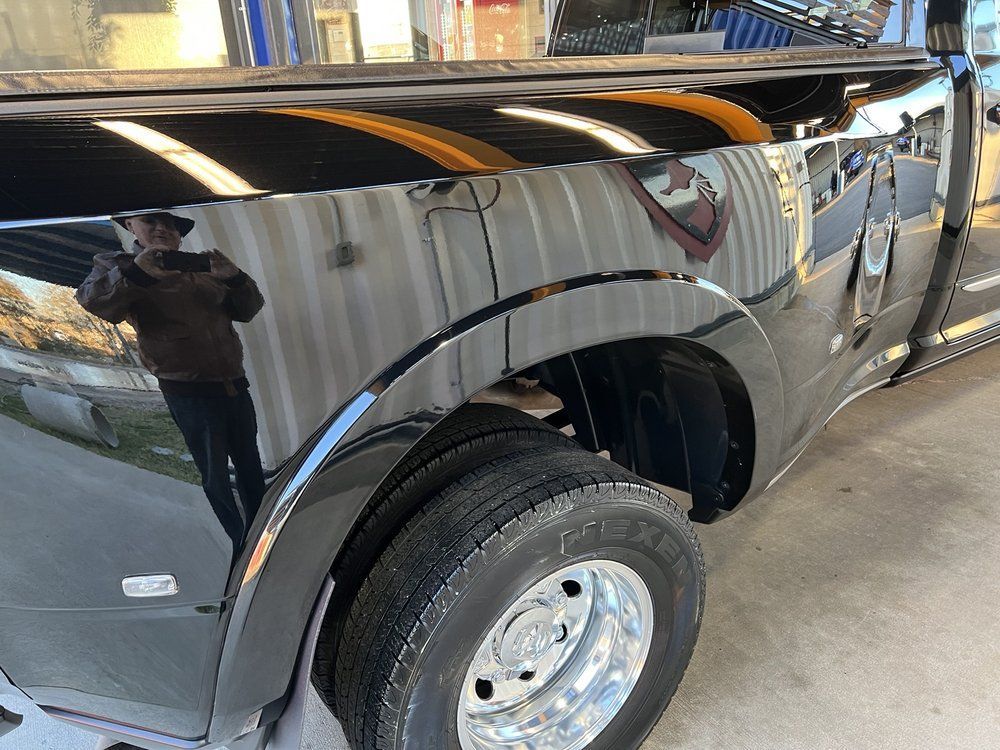 A black truck is parked on the side of the road.