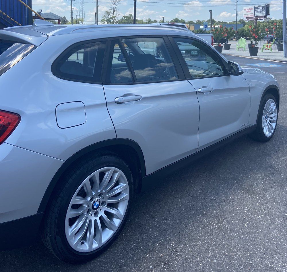 A silver bmw is parked on the side of the road