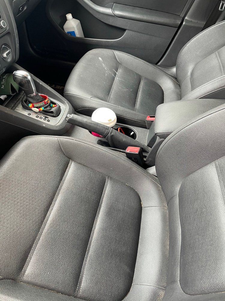 The inside of a car with a bottle of milk in the center console.